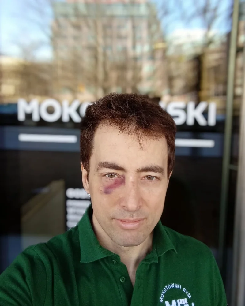 Maciek Głuszak w koszulce Mokotowskiego Gymu przed wejściem do klubu